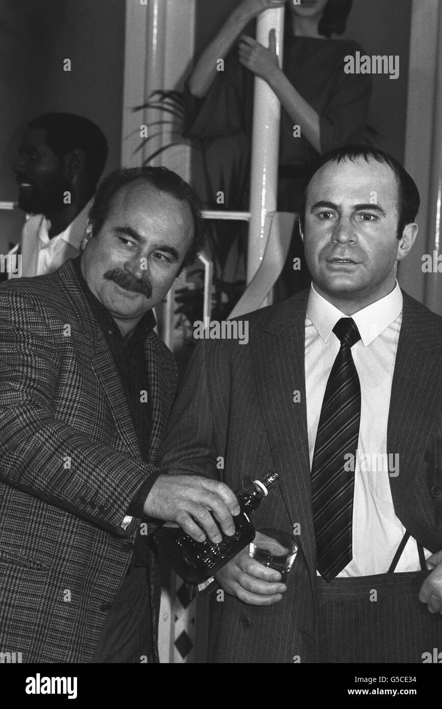 British actor Bob Hoskins offers a drink to his waxwork counterpart at Madame Tussaud's Waxwork Museum in London. Stock Photo