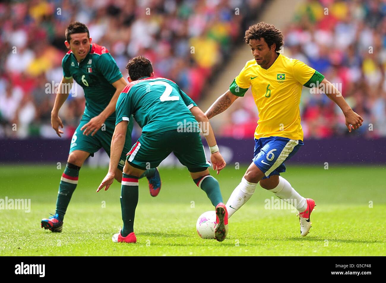 Brazil's Marcelo in action with Mexico's Israel Sabdi Jimenez Nanez (centre) and Hector Herrera Rubio (left) during the Football Men's Gold Medal Match between Mexico and Brazil at Wembley Stadium, London. Stock Photo