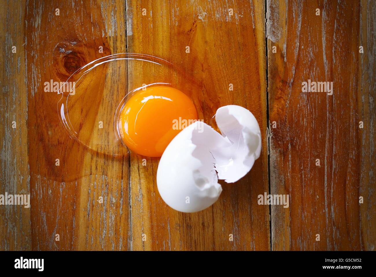 Broken egg on wooden table background Stock Photo