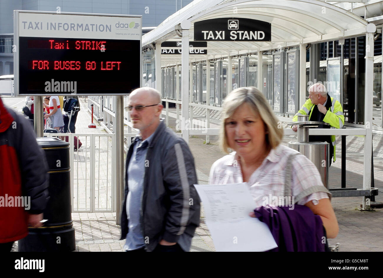 Passengers wait for a Taxi at an empty rank in Dublin Airport as a taxi ...