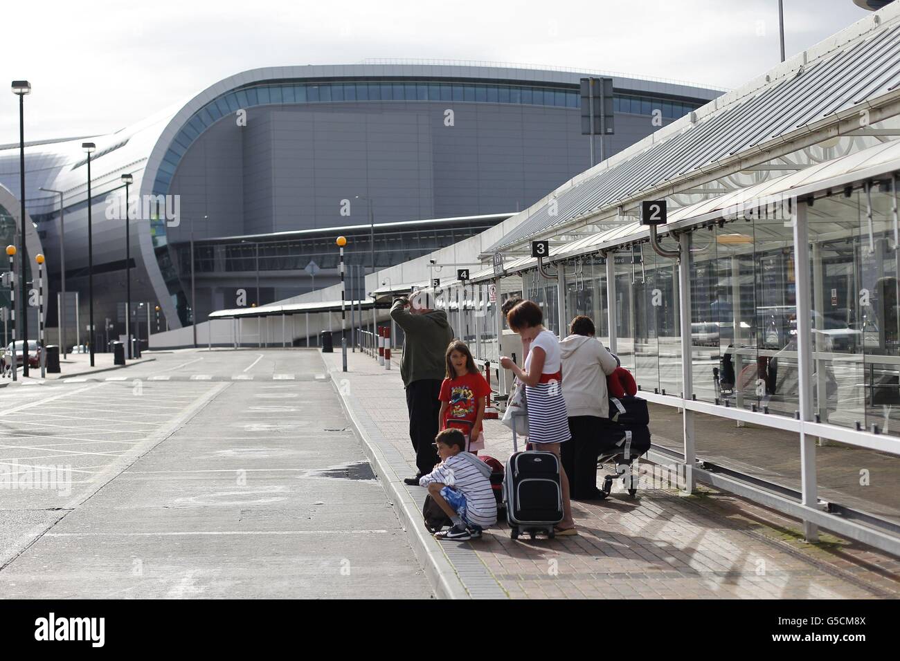 Passengers wait for a Taxi at an empty rank in Dublin Airport as a taxi ...