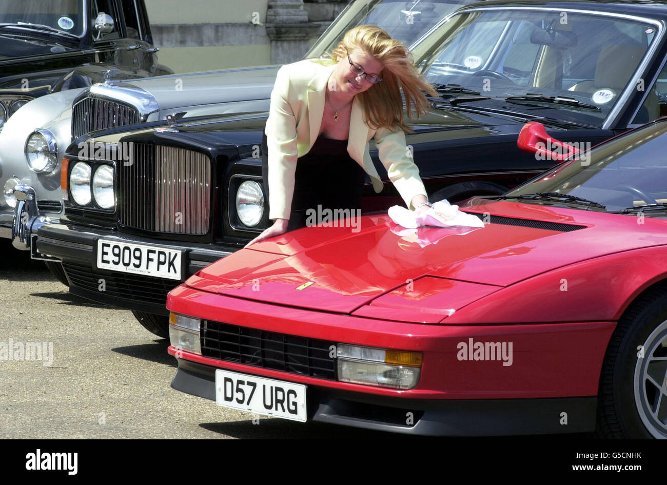 Christie's employee Cynthia Paris polishes the bonnet of rock star Elton John's 1987 Ferrari Testarossa sports car, ahead of an auction of 20 cars from his collection at Christie's, in London, on 05/06/01. Stock Photo