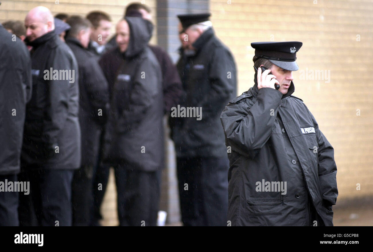 A prison officer talks on his mobile phone outside Barlinnie Prison in Glasgow as prison officers around Scotland went on strike over new shift patterns. *The Prison Officers Association of Scotland (POAS) said their members at Barlinnie, Edinburgh, Perth, Greenock, Lowmoss and Aberdeen jails had only a skeleton staff in place this morning. The union said the action, which comes after talks broke down, was in protest at new shift patterns due to be introduced at one prison. Stock Photo