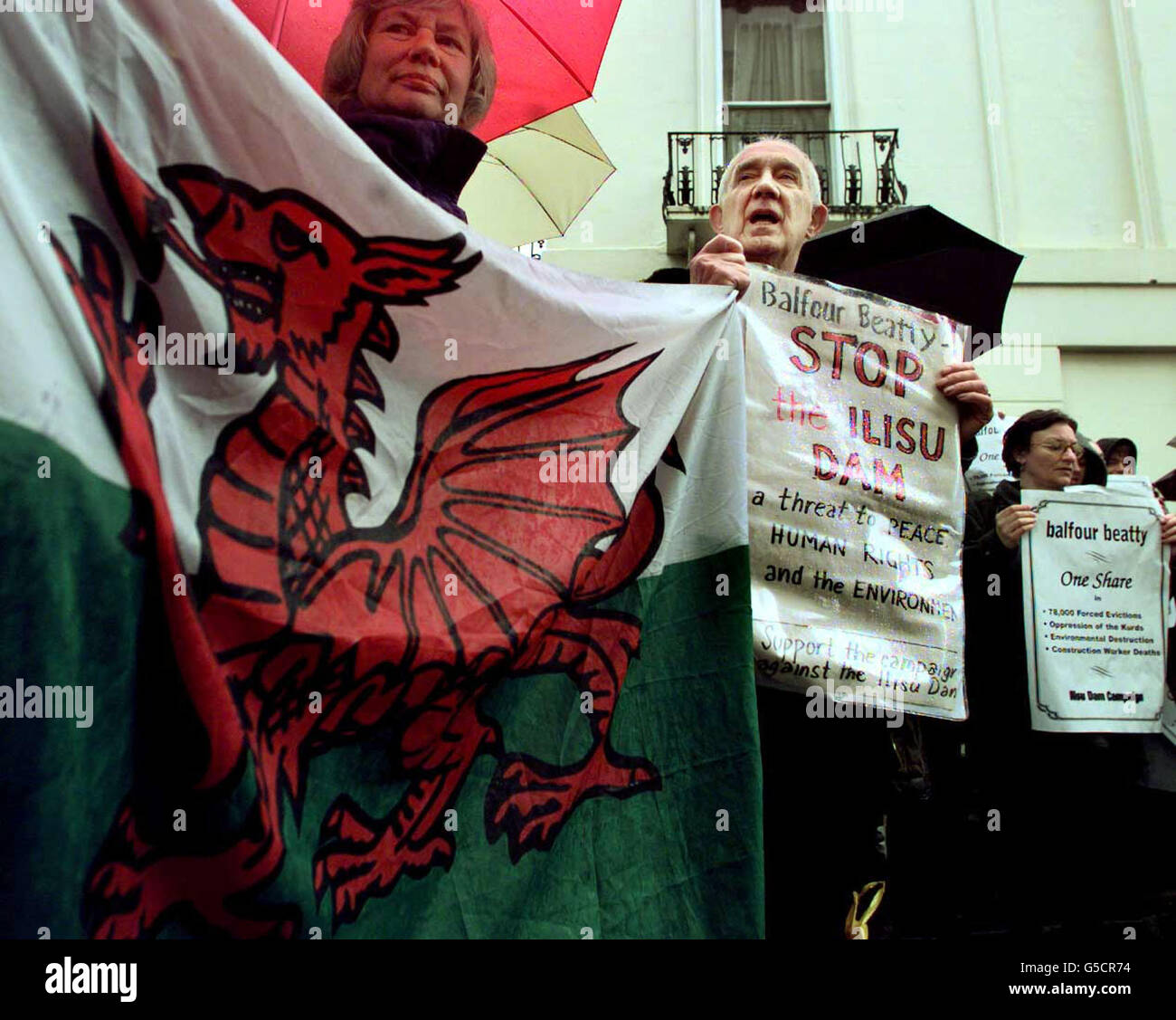 A Welsh flag is held up at a protest against engineering and construction firm Balfour Beaty - whose annual general meeting was being held today - outside the Royal Lancaster Hotel, Lancaster Gate, London. Stock Photo