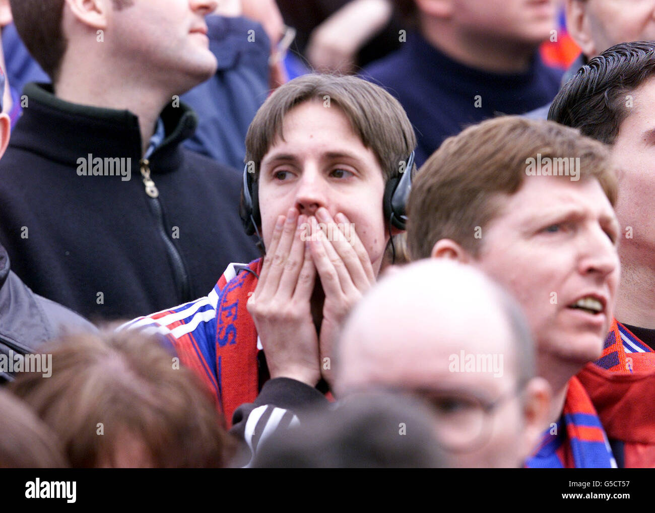 A Crystal Palace fan listens to radio during the First Division