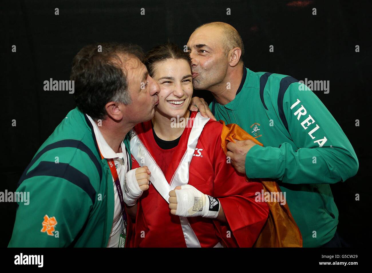 Ireland's Katie Taylor is congratulated by her father and coach Peter Taylor (right) and assistant coach Zaur Anita (left)after her win against Tajikistan's Mavzuna Chorieva during their Women's Boxing Light (60kg) Semi Final bout at the ExCel centre, London, on the twelfth day of the London 2012 Olympics. Stock Photo