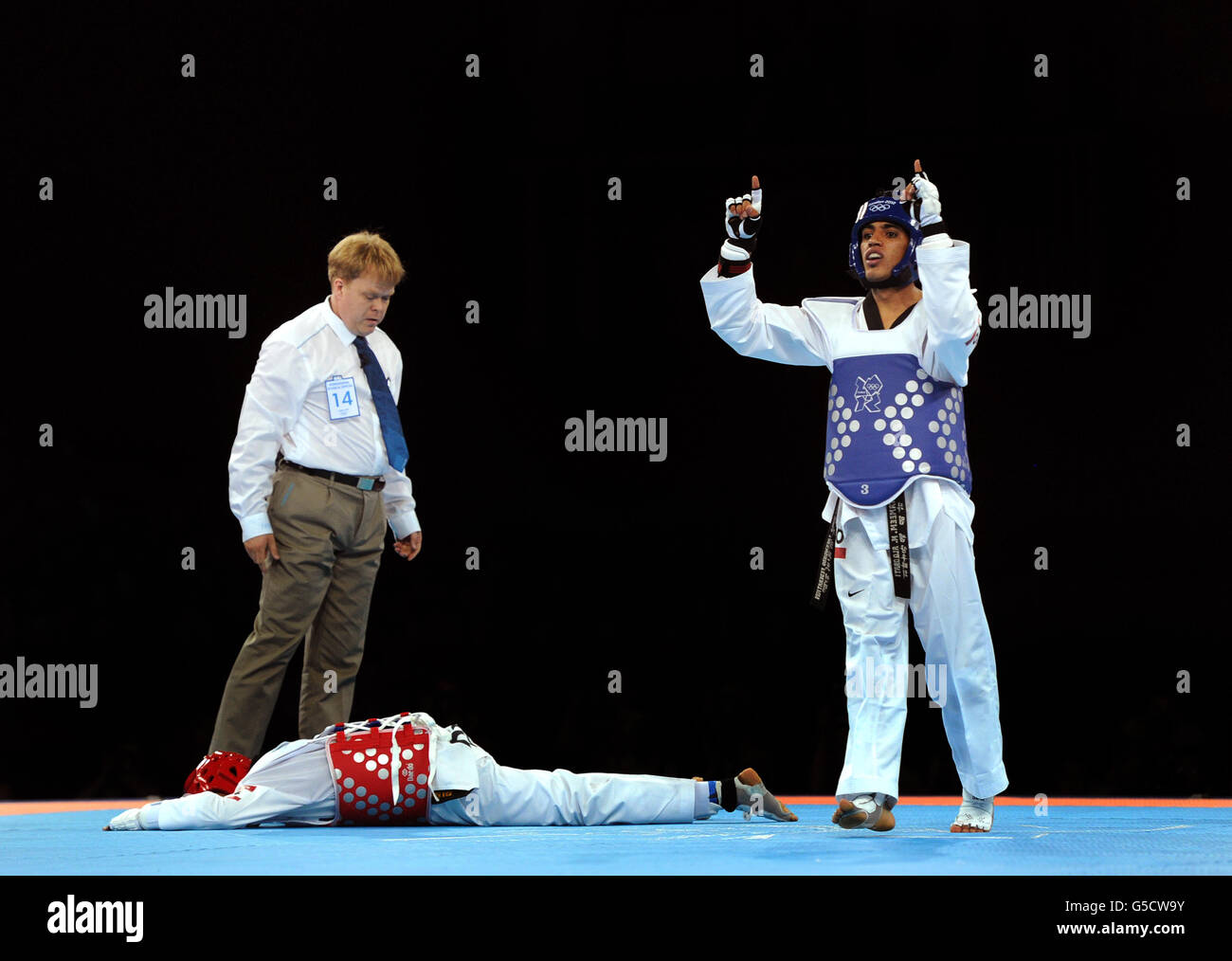 Yemen's Tameem Mohammed Ahmed Al-Kubati (blue) reacts as he competes against Dominican Republic's Yulis Mercedes Reyes during the Men's (-58kg) Taekwondo at the ExCel centre, London Stock Photo