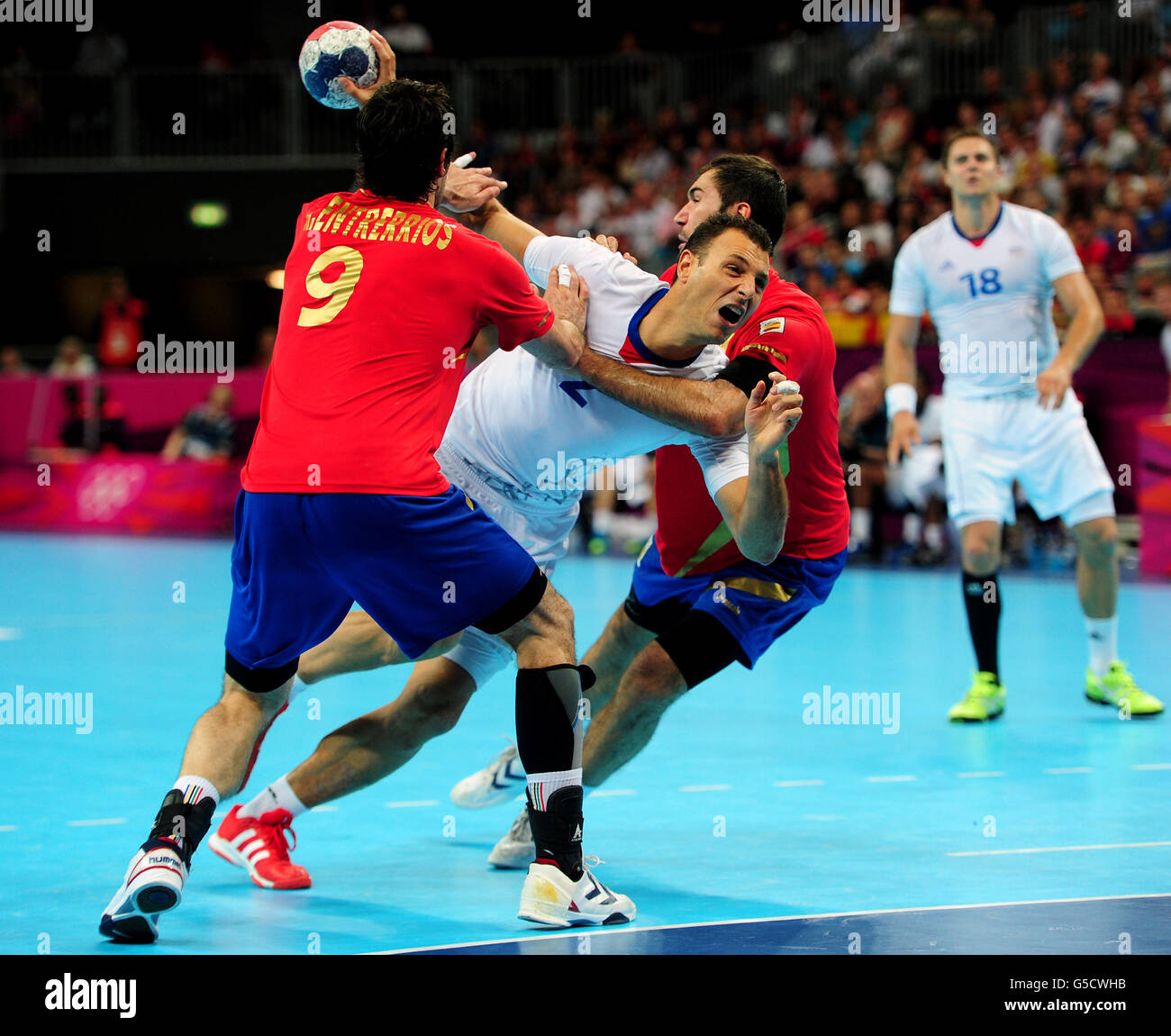 France's Jerome Fernandez (centre) is tackled by Spain's Raul Rodriguez Entrerrios during the Handball Men's Quarterfinal match at the Basketball Arena, Olympic Park. Stock Photo