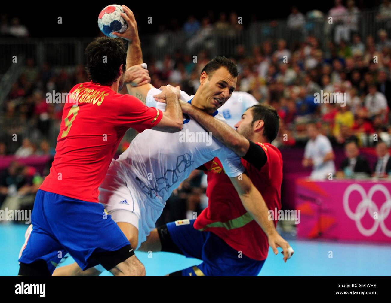 France's Jerome Fernandez (centre) is tackled by Spain's Raul Rodriguez Entrerrios during the Handball Men's Quarterfinal match at the Basketball Arena, Olympic Park. Stock Photo
