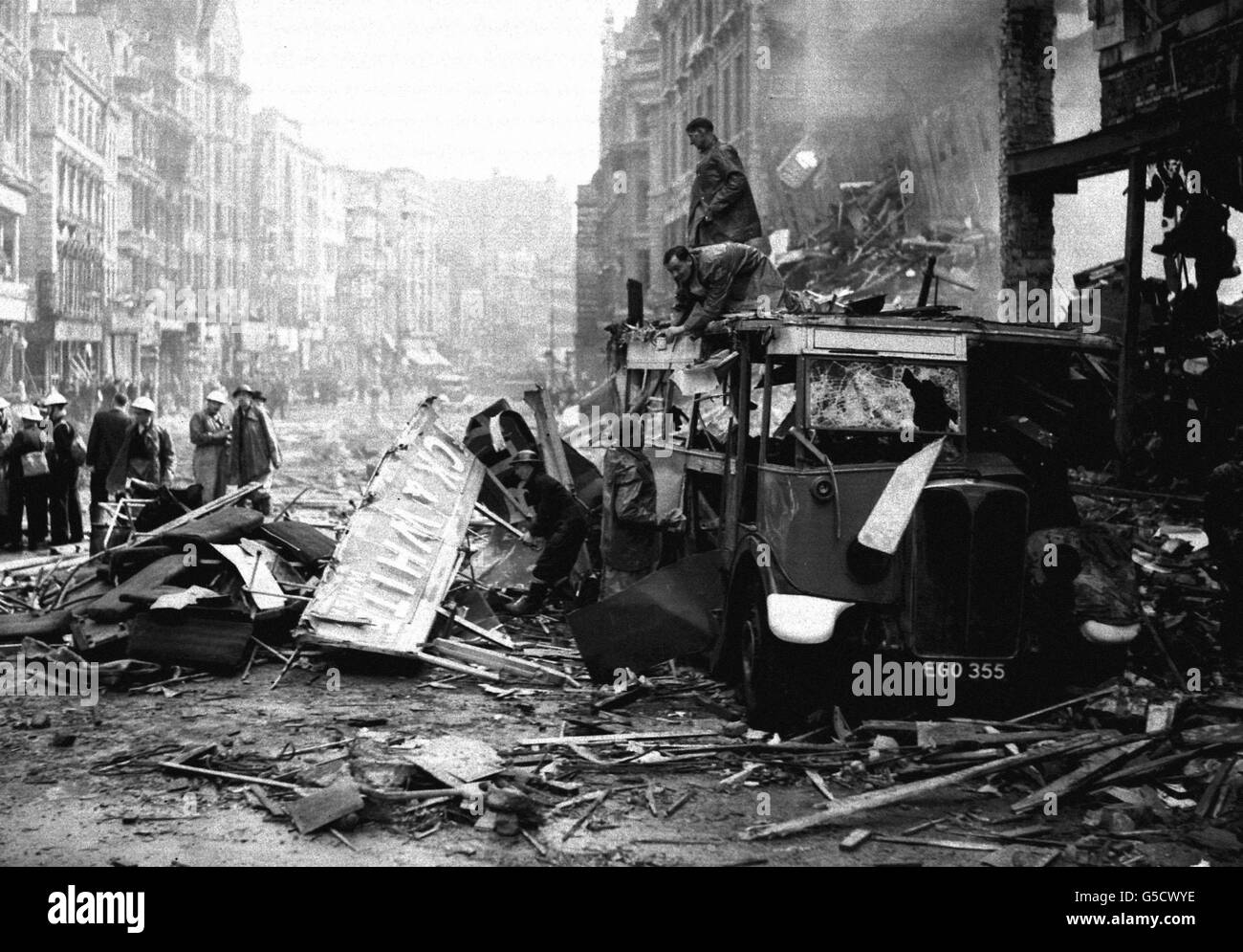 Rescue workers attend to a badly damaged bus in High Holborn, London, amid the damage caused by a Luftwaffe bombing raid during the blitz. Stock Photo