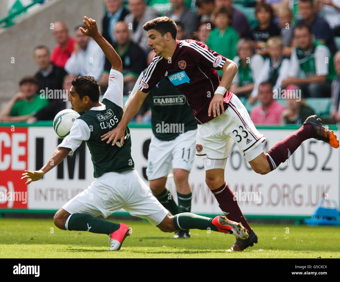 Hibernian's Jorge Claros (left) is tackled by Hearts' Callum Paterson during the Clydesdale Bank Scottish Premier League match at Easter Road, Edinburgh. Stock Photo