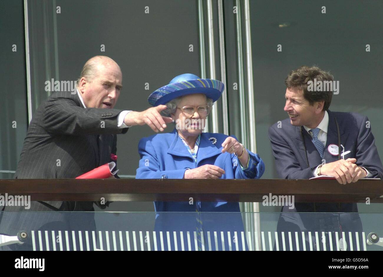 British Queen Elizabeth II talks with her horse racing advisors, as she attends the Vodafone Derby meeting at Epsom in Surrey. Stock Photo
