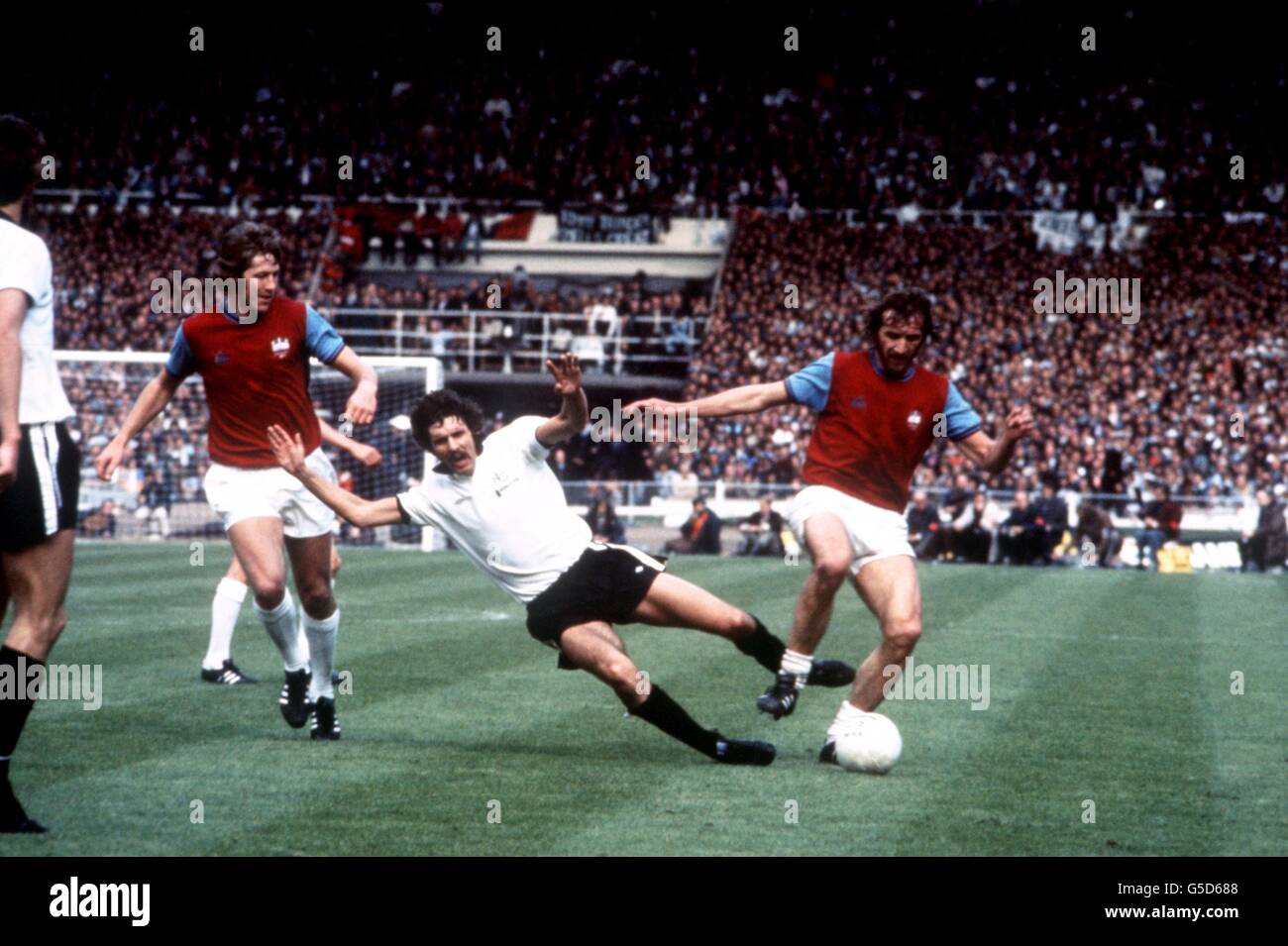 Soccer - FA Cup Final - West Ham United v Fulham. Tommy Taylor and Billy Bonds both West Ham United, Surround John Lacy of Fulham Stock Photo