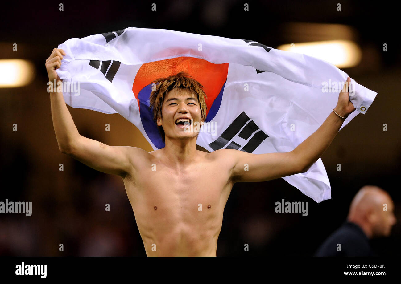 South Korea's Sungyueng Ki celebrates with his country's flag after his side beat Japan to win the men's football Bronze medal match at the Millennium Stadium Stock Photo