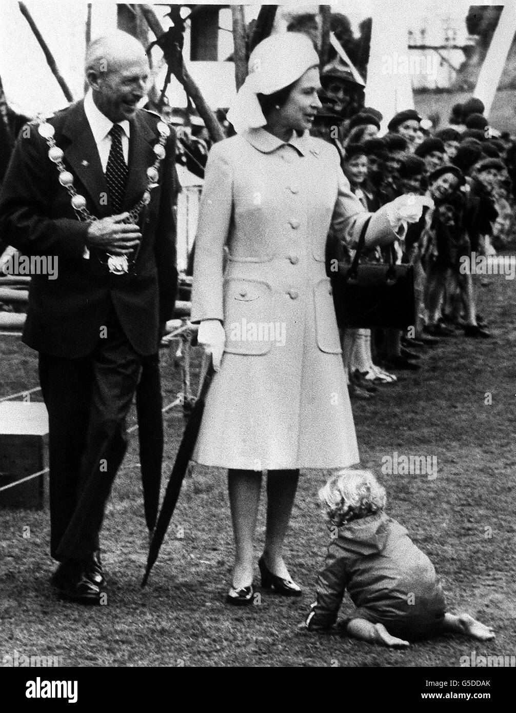 A toddler provides an amusing interlude for the Queen duing her visit to Timaru, New Zealand. Stock Photo