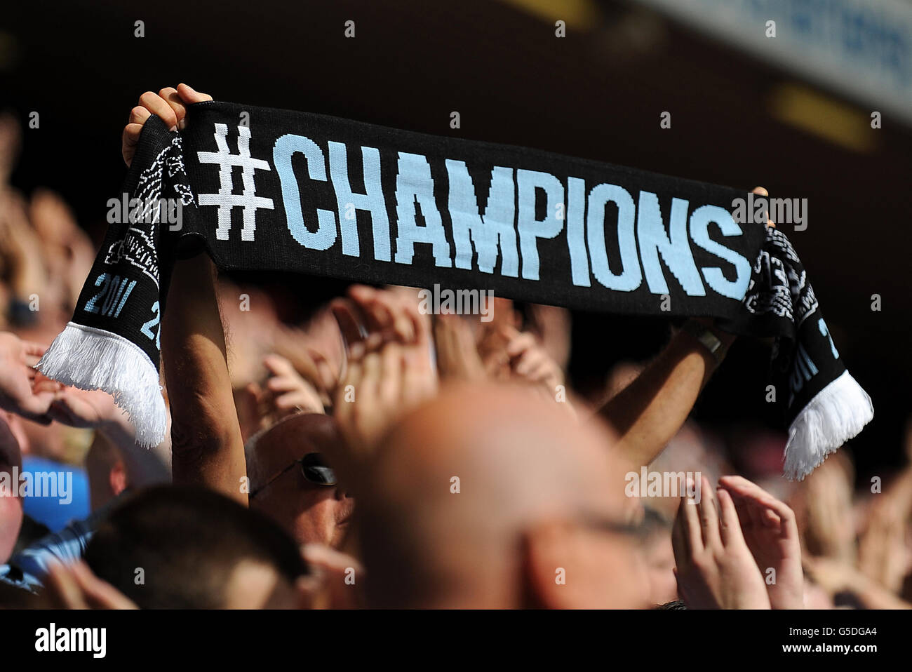 Manchester city fan holds up scarf in the hi-res stock photography
