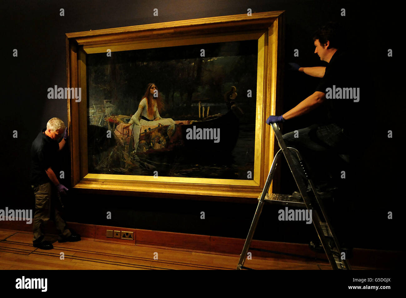 Two Birmingham Museum & Art Gallery workers hang John Williams Waterhouse's The Lady of Shalott before an exhibition of Victorian paintings at the Birmingham Museum & Art Gallery, Birmingham. Stock Photo