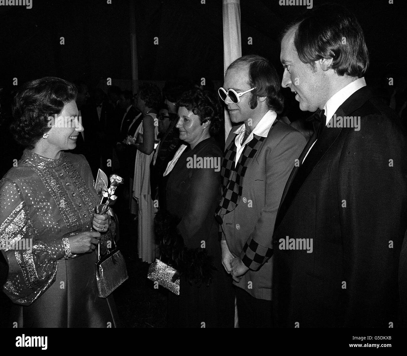 Bespectacled pop star Elton John and television personality David Frost being presented to the Queen at Windsor when they were among a host of stars appearing in a gala variety performance in the Big Top at Home Park in aid of the Queen's Silver Jubilee Appeal. Stock Photo