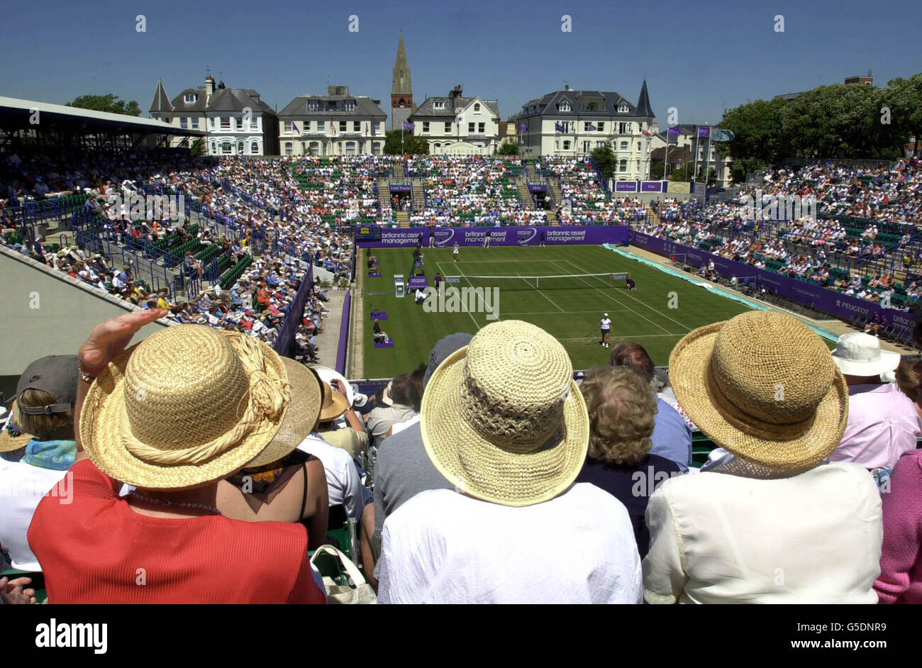 Tennis supporters sit in the sunshine as they watch the action in the Britannic Asset Management International Championships at Eastbourne, 2001. The tennis tournament is part of the build up to next weeks Lawn Tennis Championships at Wimbledon. Stock Photo