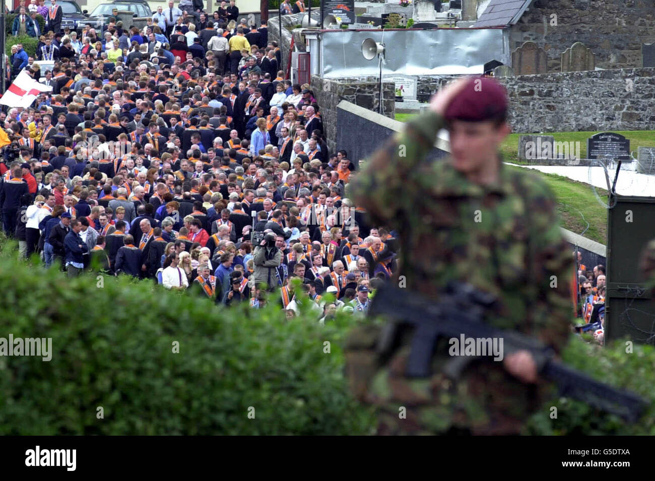 A British soldier from the Parachute Regiment watches as Orange Order Members and supporters are halted at a barrier erected by the security forces. * They were prevented from marching from their Church Service at Drumcree along the Nationalist Garvaghy Road in Portadown, Ulster. Stock Photo