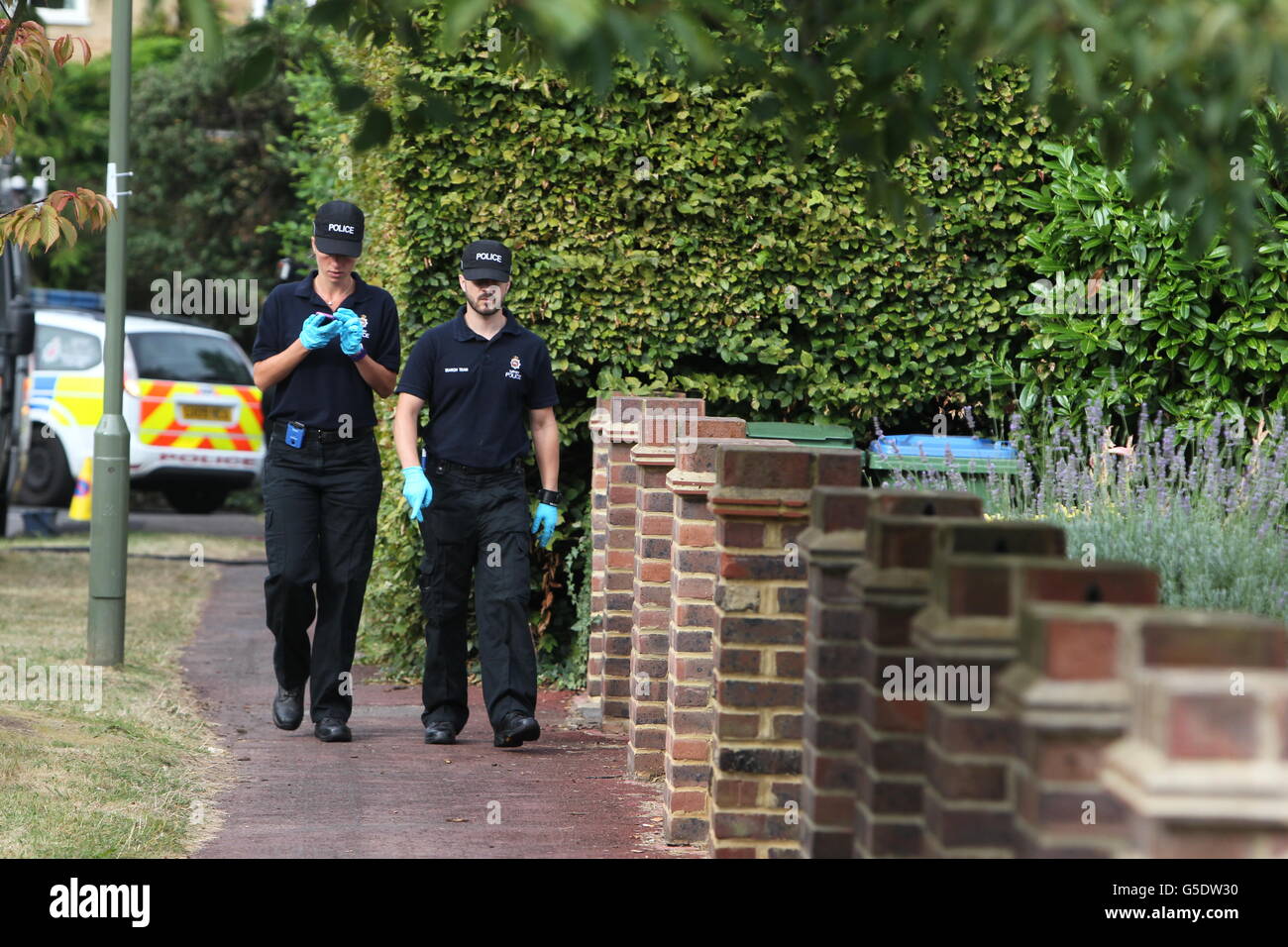 Police walk close to the home of Saad al-Hilli in Claygate, Surrey, as they evacuated an area around his home due to 'concerns' about items found at the address. Stock Photo