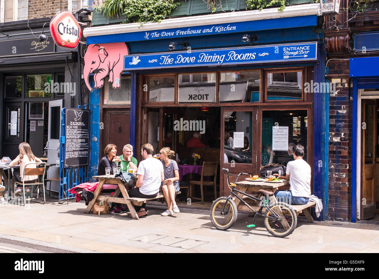 People sitting outside a pub enjoying a beer in the cool hipster area Broadway Market, East London Stock Photo