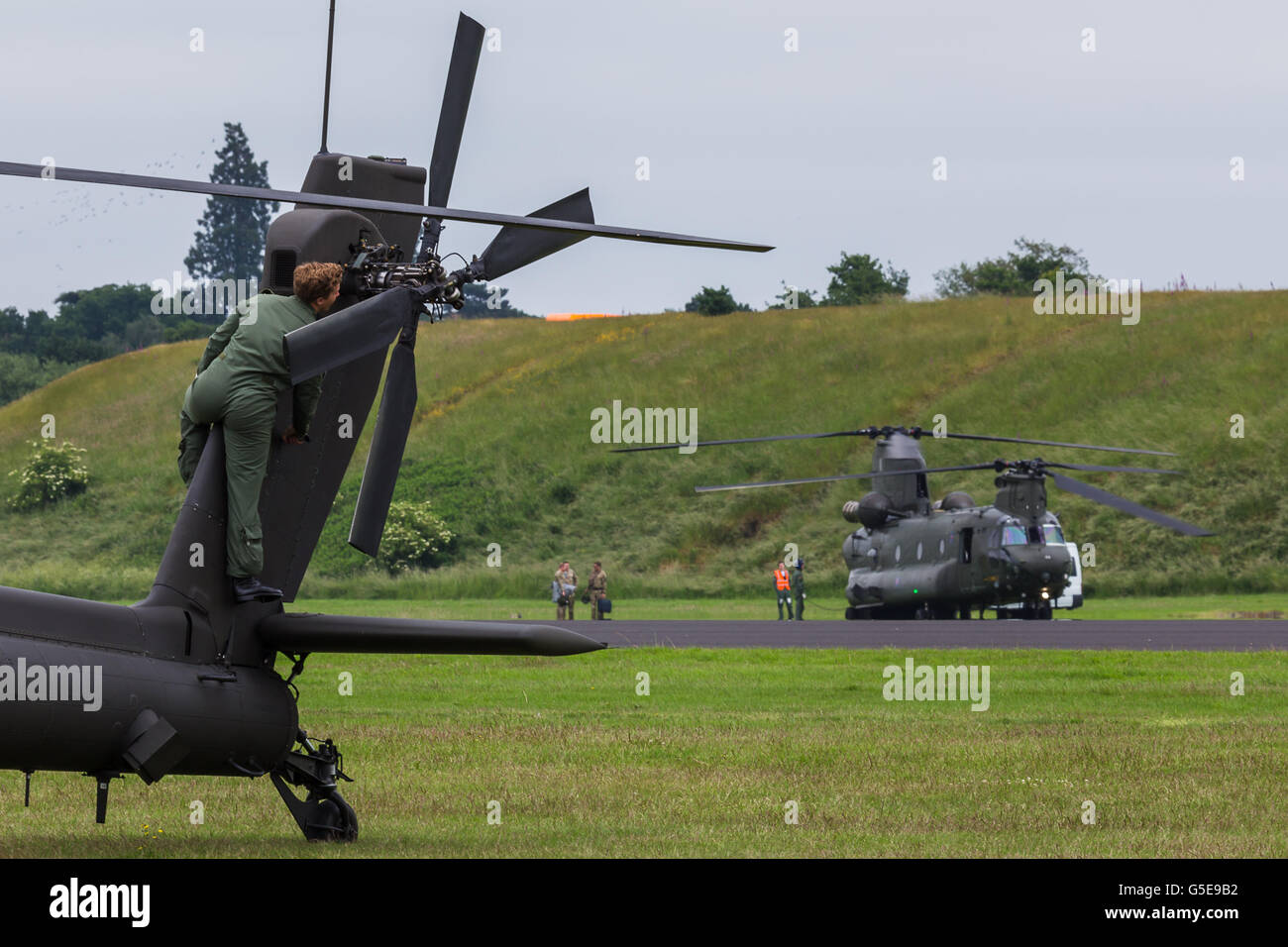 Ground crew prepare the Apache in front of the Chinook Stock Photo