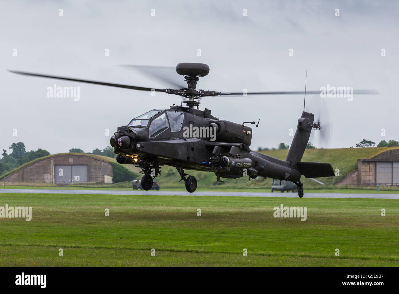 Apache AH1 gunship lands on the grass. Stock Photo