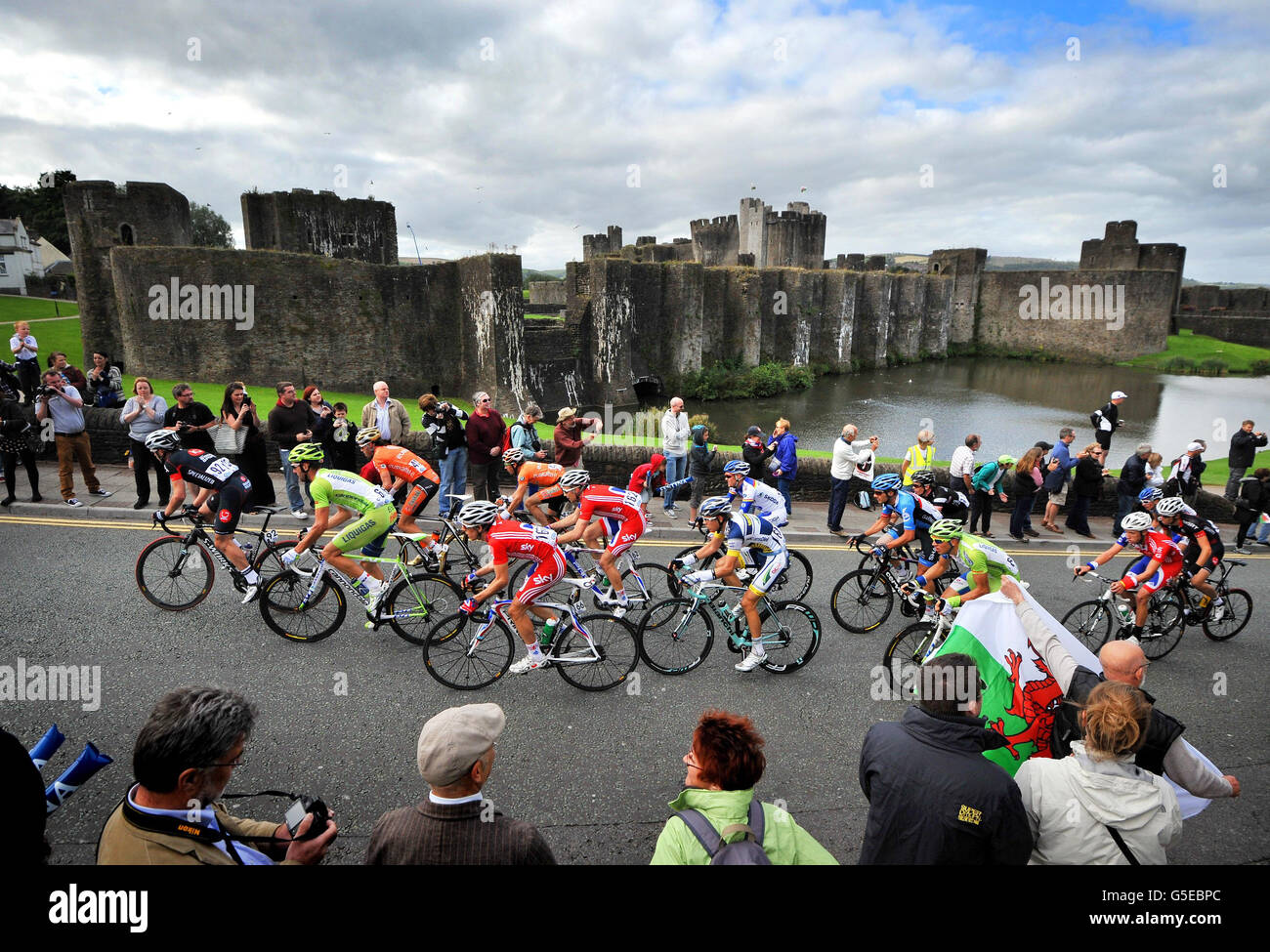 Riders make their way past Caerphilly Castle during the sixth stage of the Tour of Britain in Caerphilly. Stock Photo