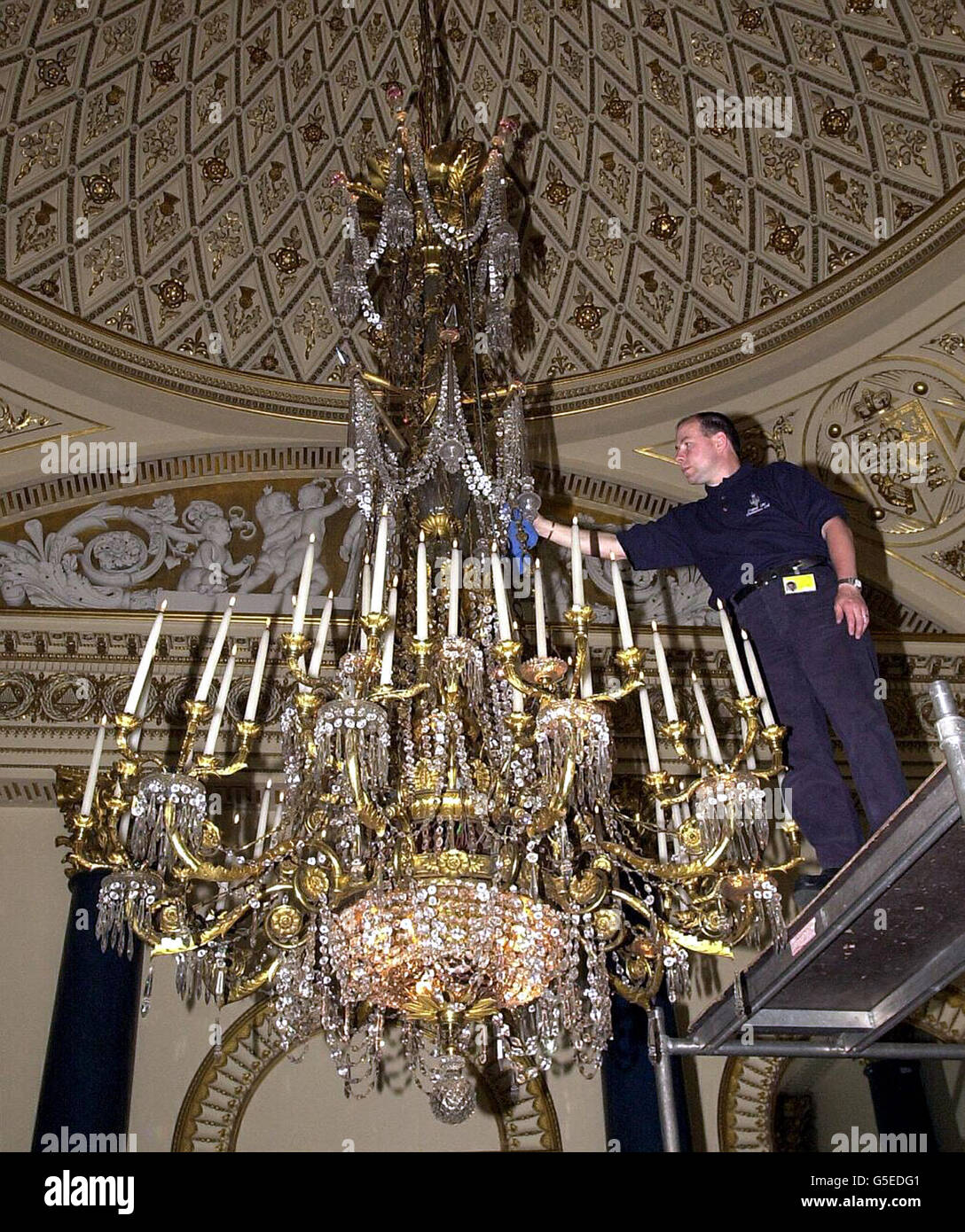 Technician Mark Boyd cleans the largest chandelier in the Music Room