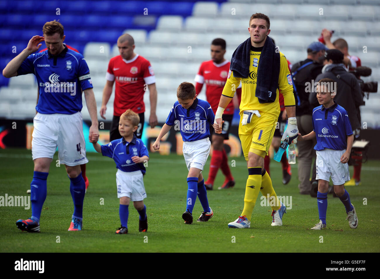 Birmingham City's Stephen Caldwell (l) and goalkeeper Jack Butland walk out with the matchday mascots at St Andrews Stock Photo