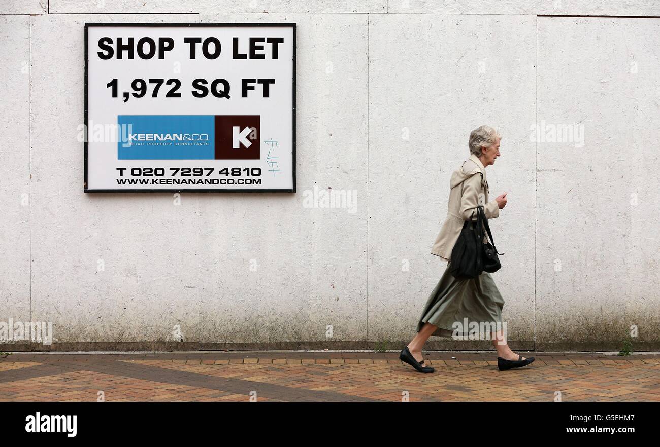 A woman makes her way past an empty shop in Stockport. The number of vacant shops blighting the UK's high streets and shopping centres has continued to rise, a report revealed today, amid grim warnings that some will never fully recover. Stock Photo