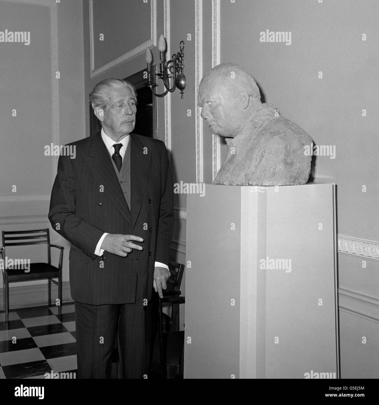 Former Prime Minister Harold Macmillan, who served as a minister under Sir Winston Churchill in war and peace, admires a bust Sir Winston which had been unveiled by Lady Spencer-Churchill (not pictured) as the Conservative Party Central Office in Smith Square, London. The bust, the work of Oscar Nemon, was commissioned by the Conservative Party as their memorial to Sir Winston. Stock Photo