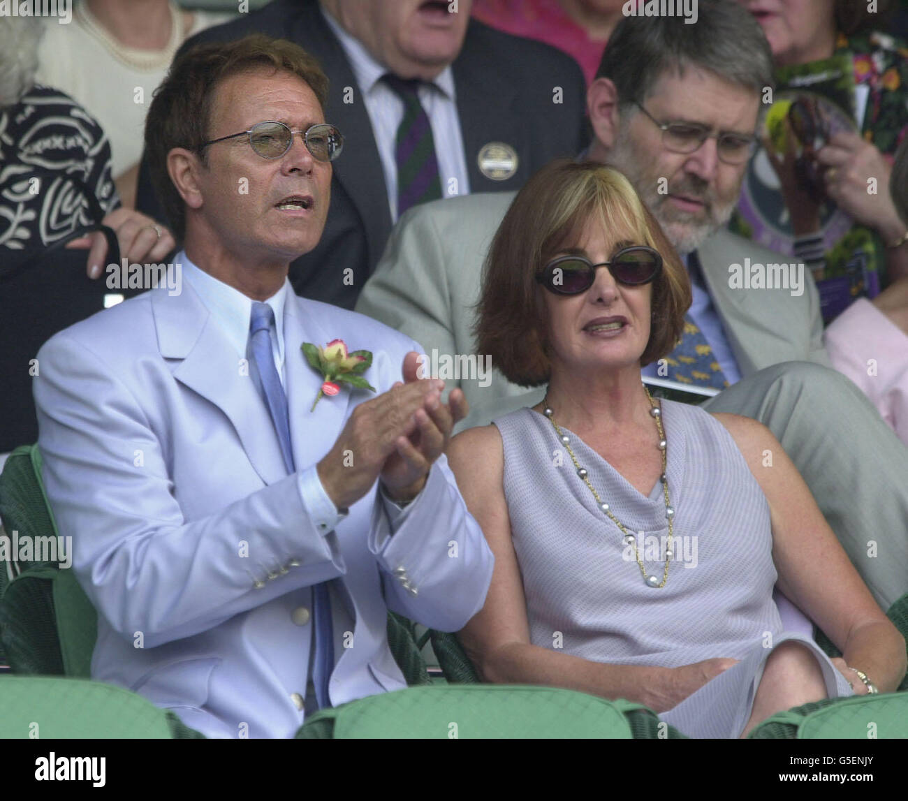 NO COMMERCIAL USE: Singer Sir Cliff Richard with guest Pat Farrar watch the Justine Henin of Belgium verses Jennifer Capriati of USA Semi Final match of the Lawn Tennis Championships at Wimbledon, London. Stock Photo