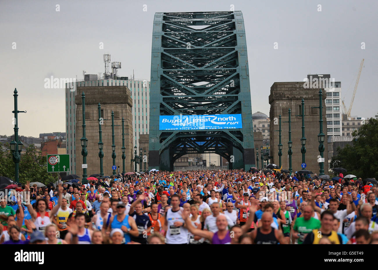 Competitors run over Tyne Bridge during the Great North Run in Newcastle. Stock Photo