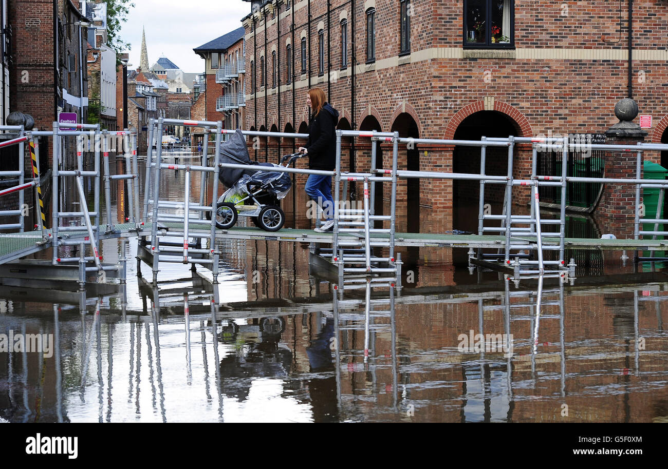 Elevated walkways carry pedestrians to walk above floodwater in York as ...