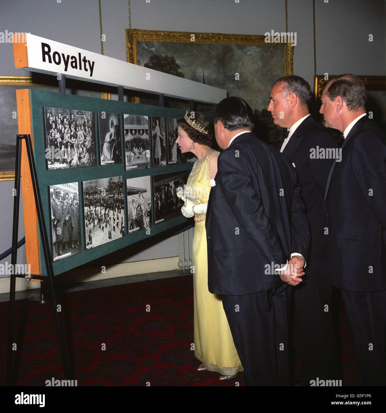The Queen looks at a collection of Royal images from the Press Association during a reception in Guildhall, London, marking the centenary of the Press Association, Britain's national news agency. With the Queen is the Chairman of the Press Association Mr W.D. Barnetson. Stock Photo