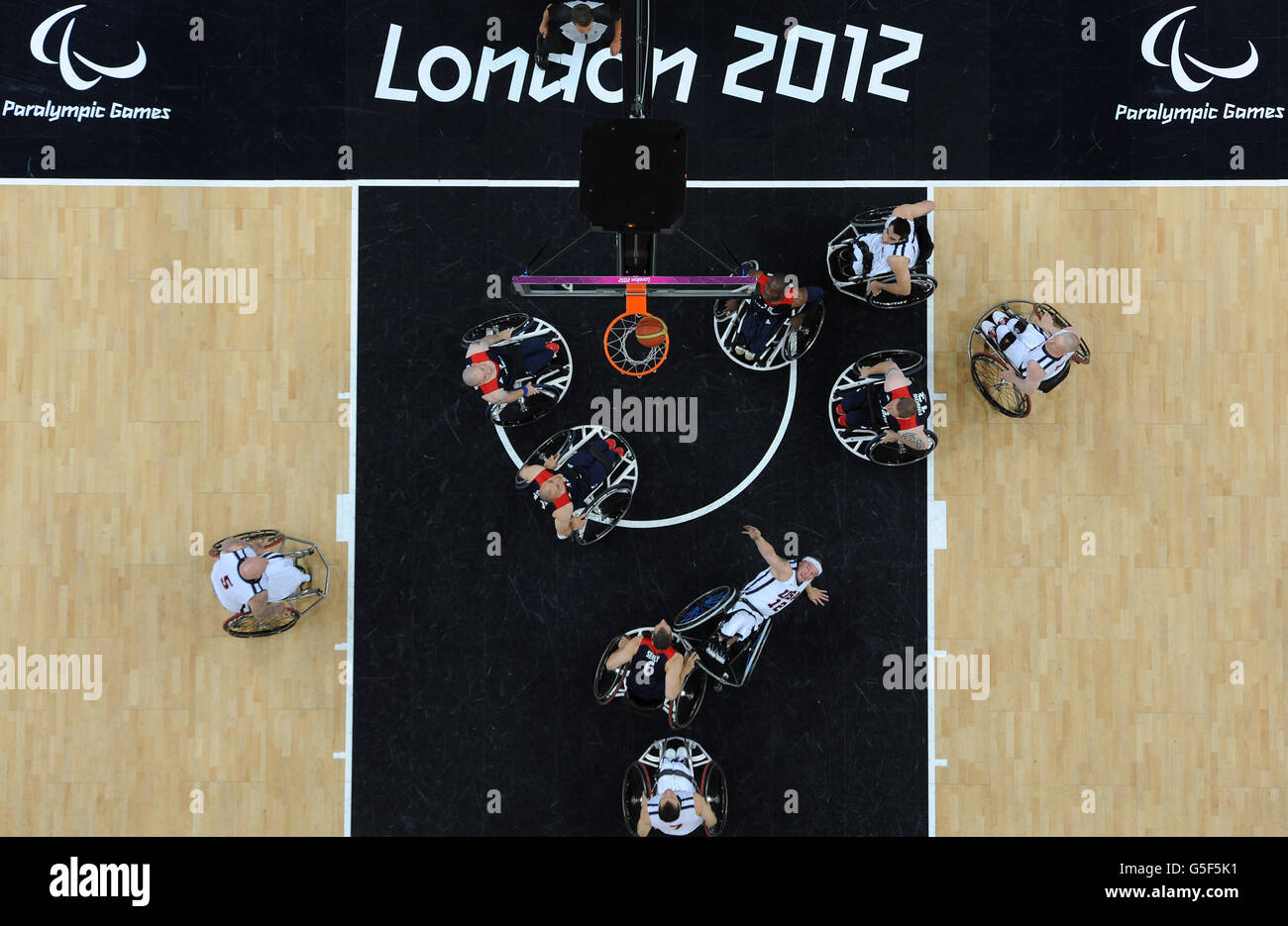 USA's Jason Nelmes falls over as he shoots during the men's wheelchair basketball bronze medal match between Great Britain and USA at the North Greenwich Arena, London. Stock Photo