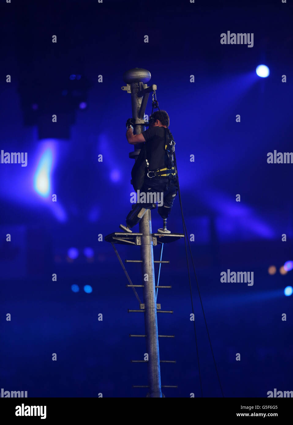 Captain Luke Sinnot climbs a flag pole during the Closing Ceremony for the London Paralympic Games 2012 at the Olympic Stadium, London. Stock Photo