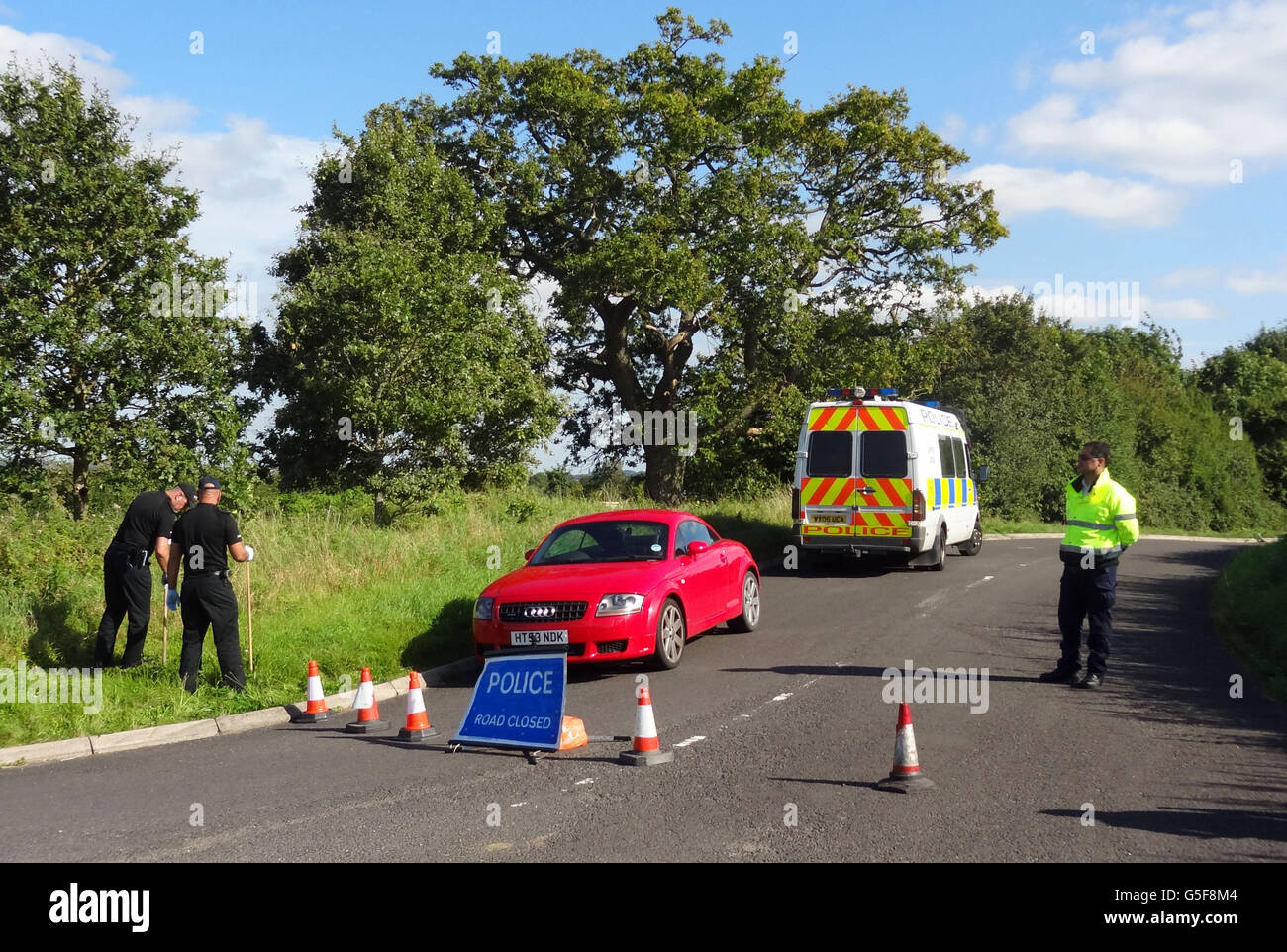 Police close to the scene in a lane in Ashill off the A358 near Ilminster, Somerset, after a young woman was discovered dead in a burning car. Stock Photo