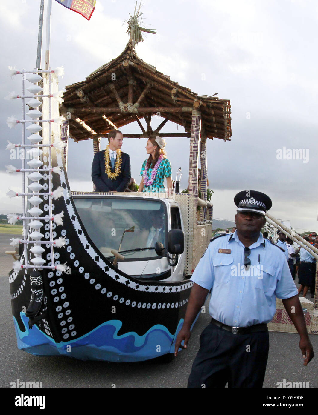 The Duke and The Duchess of Cambridge on an open-top vehicle, shaped as a traditional canoe with a leaf roof canopy as they depart from Henderson Airport, Honiara, Solomon Islands, during the nine-day royal tour of the Far East and South Pacific in honour of the Queen's Diamond Jubilee. Stock Photo