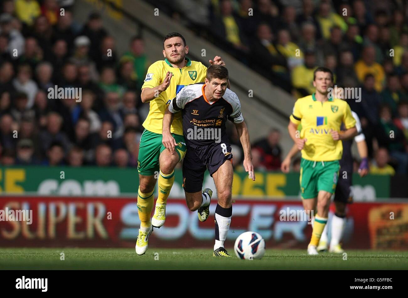 Norwich City's Robert Snodgrass (left) and Liverpool's Steven Gerrard (centre) battle for the ball Stock Photo