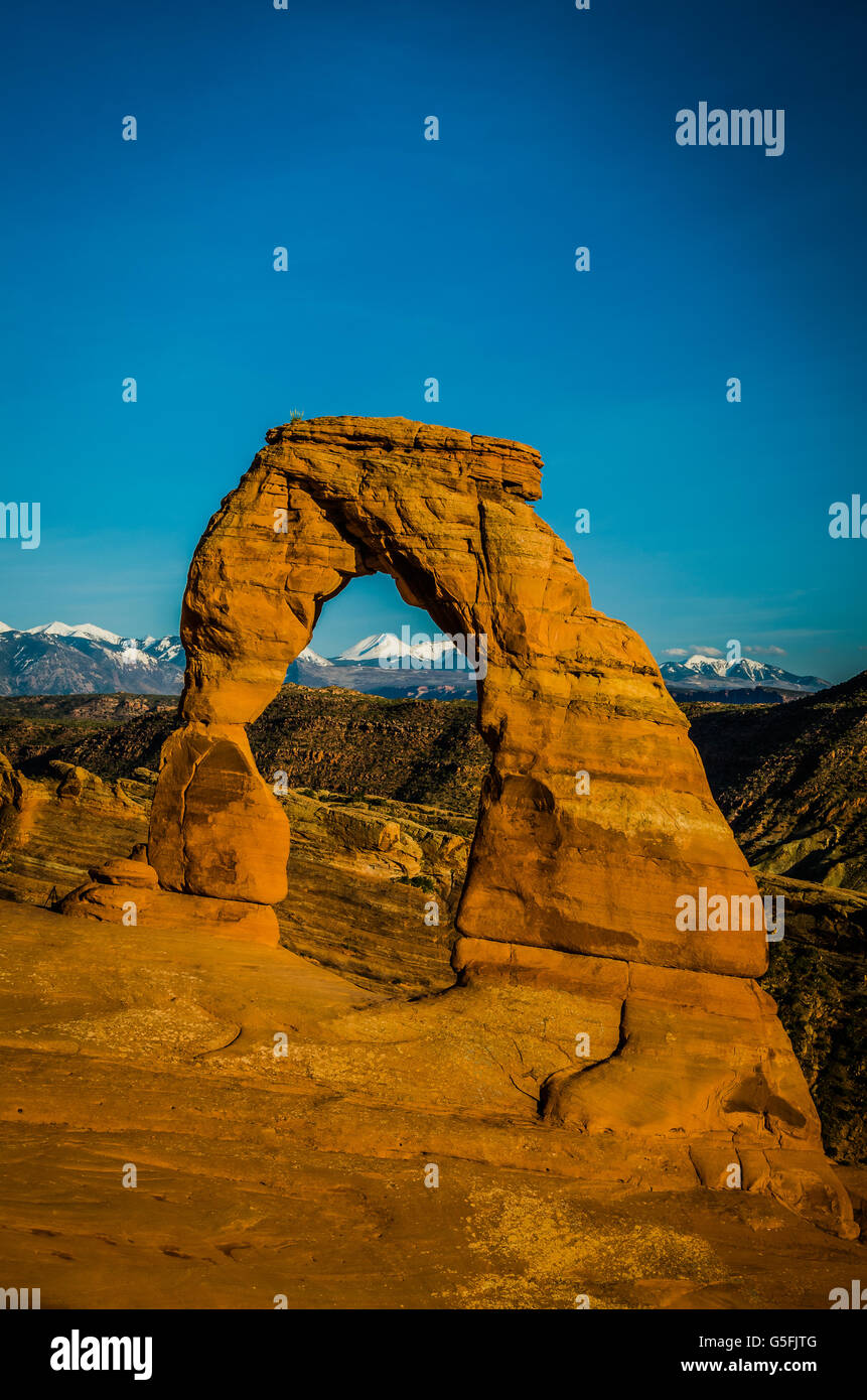 Snowy mountain range in the background under an arch in Arches National Park in wonderful Utah, during spring. stunning nature and touristic area Stock Photo