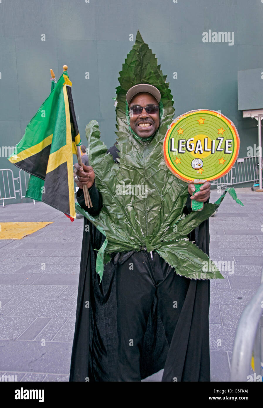 A man in Times Square dressed as a marijuana leaf holding Jamaican flags and a legalize pot sign. In New York City. Stock Photo