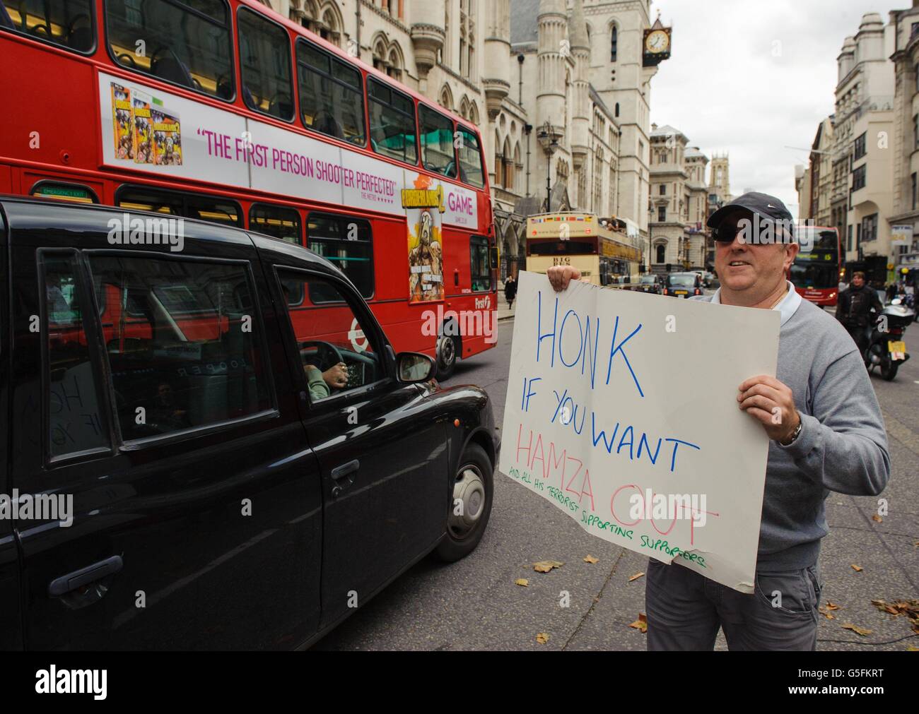 A protester holds a placard supporting the proposed extradition of radical preacher Abu Hamza and four other terror suspects outside the Royal Courts of Justice, in central London. Stock Photo