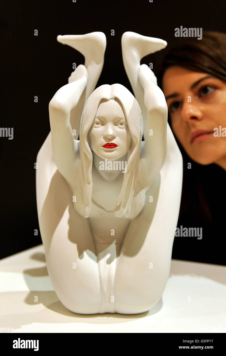 A female employee of Bonham's auctioneers in central London, studies a sculpture of supermodel Kate Moss performing Yoga produced by Marc Quinn called 'Caryatid', which goes up for auction this Thursday during the auction house's Contemporary Art &amp; Design auction, with a price tag of between &pound;50,000-70,000. Stock Photo