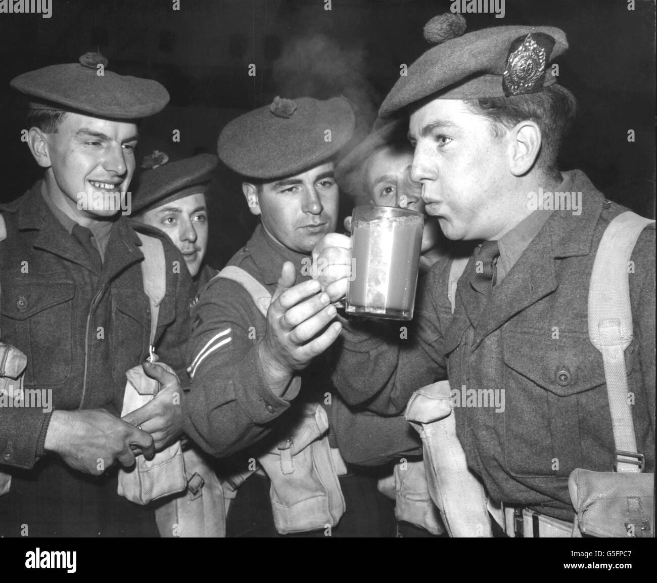 Nothing stronger was available, so Willy McLeod, of Dumbarton, celebrated his return from Port Said, Egypt, by blowing the froth from a pint mug of Naafi tea at Southampton. Willy landed with the 1st Battalion, Argyll and Sutherland Highlanders, from the troopship 'Asturias'. Stock Photo