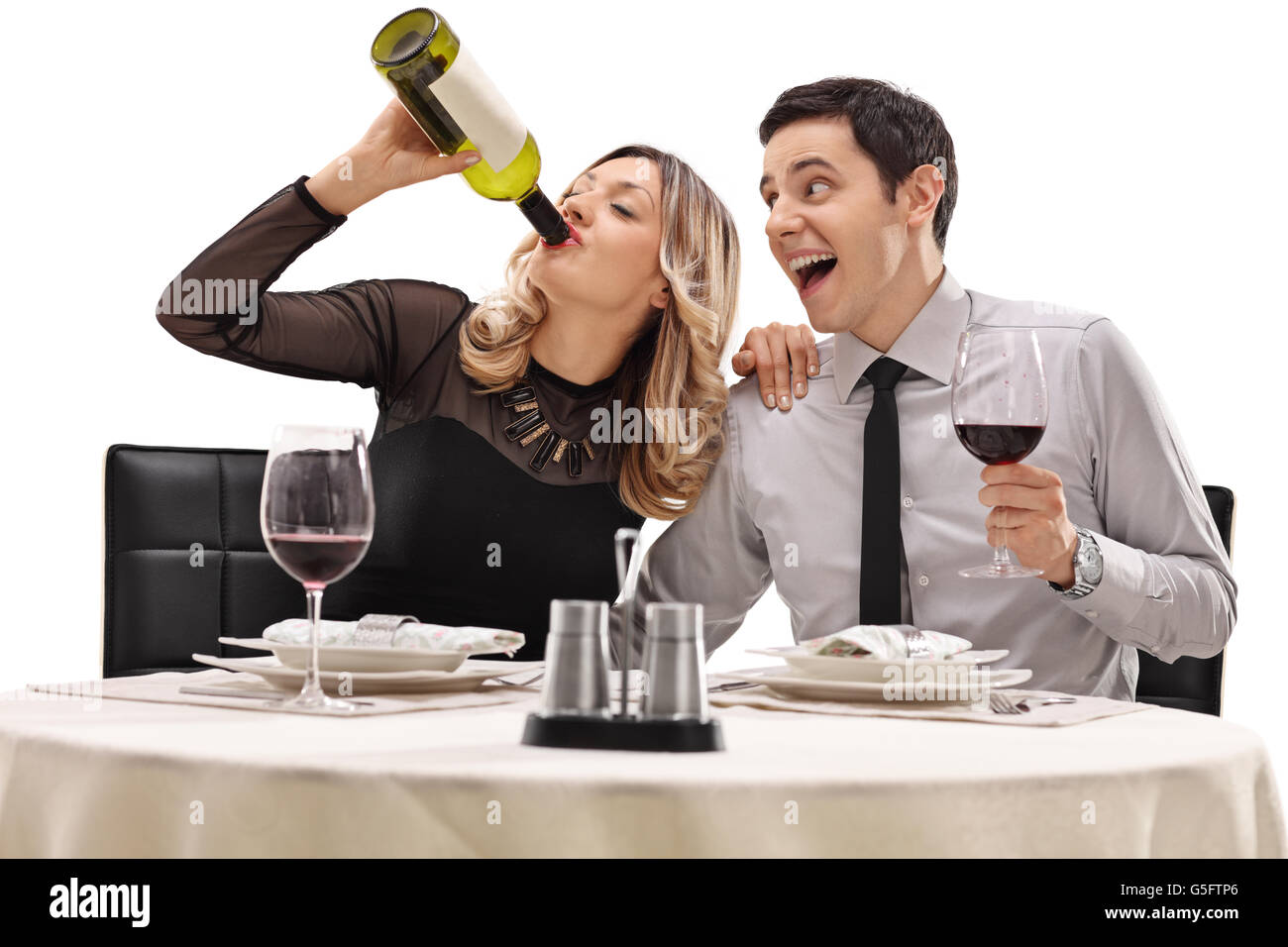 Couple drinking wine directly from the bottle seated on a date isolated on white background Stock Photo