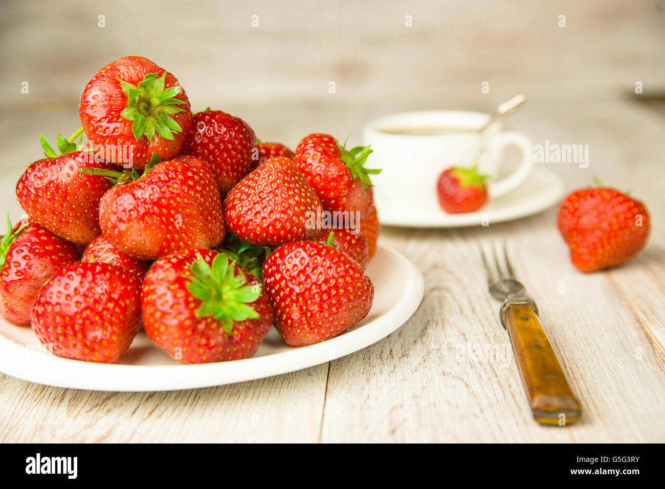Ripe red strawberries on a white plate Stock Photo