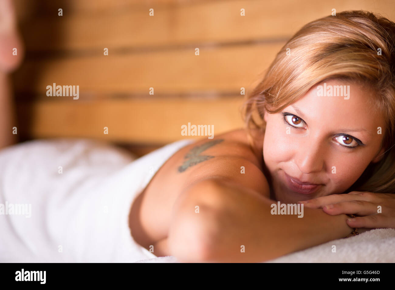 Lady relaxing in traditional wooden sauna. Stock Photo